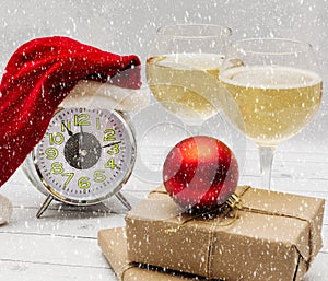 New Year or Christmas composition - an alarm clock in a Santa Claus hat, wine and gifts. New Year and Christmas concept