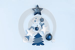 New Year and Christmas composition in the form of chrismas tree. Stars, christmas balls, toys on blue background. Top view, flat
