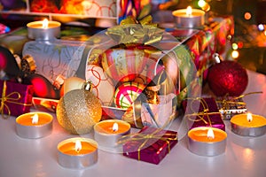 New Year and Christmas composition: gift boxes, Christmas balls and burning candles