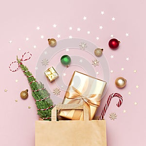 New Year Christmas composition. Paper bag and holiday decorations golden gift Christmas balls fir branches confetti Candy Cane on