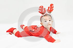 New year and Christmas concept with 5 months old cute newborn baby boy wearing christmas antlers of a deer,red clothes lying on