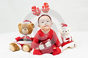 New year and Christmas concept with 5 months old cute newborn baby boy wearing christmas antlers of a deer,red clothes sitting on