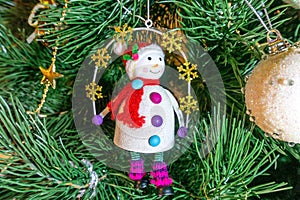 New Year and Christmas concept. Christmas tree decoration - vintage snowman figurine. Macro, selective focus, horizontal photo.