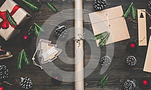 New Year or Christmas concept, wrapping paper, cup of coffee, fir branches, cones, gift, on wooden background flat lay