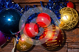 New Year and Christmas decoration balls closeup view on wooden background. Golden, blue and red balls with blue decorative ribbons