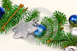 New Year and Christmas decoration with green fir tree branches and blue and silver shiny xmas traditional balls and baubles