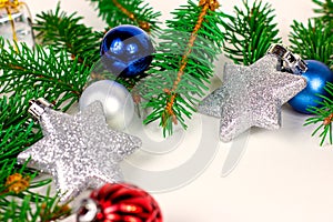 New Year and Christmas decoration with green fir tree branches and blue and silver shiny xmas traditional balls and baubles.