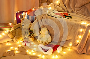 New year or christmas decoration in home interior. At night, the room glows with festive lights. A lots of gifts and decorations.