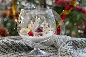 New Year and Christmas decoration in a wine glass on the Christmas tree background, close-up, selective focus