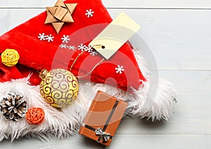 New year and christmas decorations. Santa hat white background top view. Santa hat with christmas gift box. Christmas