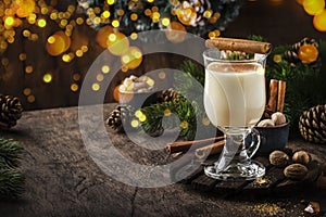 New Year or Christmas Eggnog cocktail - hot winter or autumn drink with milk, eggs and dark rum, sprinkled with cinnamon and