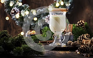New Year or Christmas Eggnog cocktail - hot winter or autumn drink with milk, eggs and dark rum, sprinkled with cinnamon and