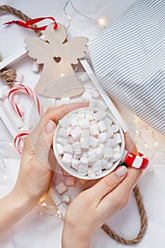 New Year or Christmas flat lay top view with Hot cacao coffee chocolate with marshmallows mug in women hands Xmas holiday