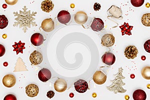 New Year and Christmas frame. Red and golden Christmas decorations - shiny balls, stars, pine cones and decorative ribbon on white