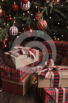 New Year and Christmas gifts under the tree in red paper.