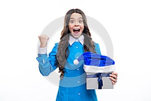 New Year or Christmas holiday gift. Excited face. Child with gift present box on isolated studio background. Gifting for