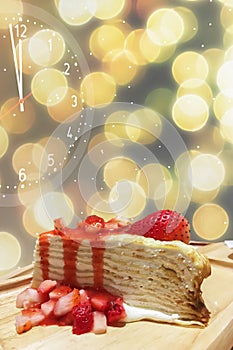 New Year and Christmas holiday image of freshness strawberry crape cake dessert with clock almost midnight time.