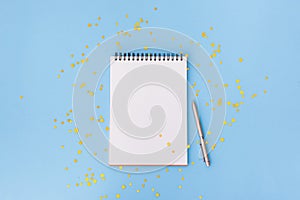 New year, Christmas or holiday wish list, goals, resolutions concept. Notepad and pen on blue background. Banner with empty space