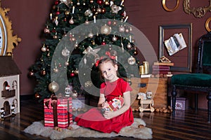 New Year 2020! Christmas, holidays and childhood concept - happy little girl with nutcracker and presents at christmas tree at hom