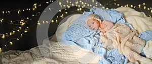 New Year Christmas holidays scene - cute newborn baby boy in funny hat lying on knitted beige blanket with Christmas