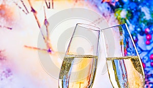 New Year or Christmas at midnight with champagne flutes make cheers on clock background