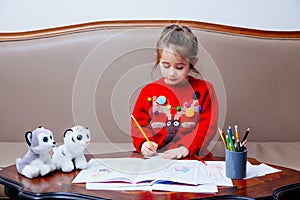 New year christmas pensil little girl writes letter Santa red jacket toy pen kid table sofa