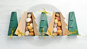 New Year and Christmas sweets. Cookies in the form of walnuts in Christmas tree-shaped boxes.