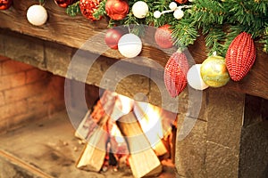 New Year / Christmas tree with colorful festive decorations on the fireplace