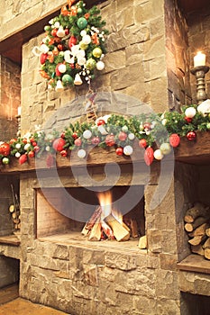 New Year / Christmas tree with colorful festive decorations on the fireplace