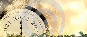 New Year 2022 clock and fireworks background.