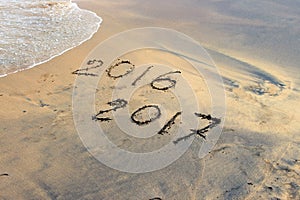 New Year 2017 is coming concept - inscription 2016 and 2017 on a beach sand
