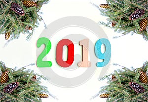 New Year composition with 2019 numbers in a frame of green fir-tree branches with cones.