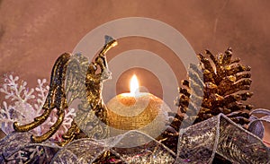 New-year composition with a candle by a gold cone and angel. Merry Christmas and Happy New Year