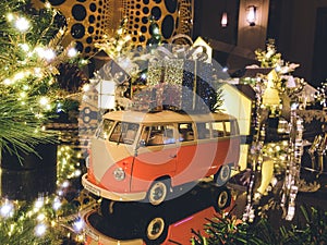 New year composition. Orange bus toy with gifts and the Christmas tree on the background