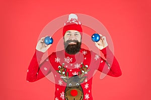 New year concept. Hipster smiling cheerful bearded man wear winter sweater and hat hold balls. Christmas party. Winter