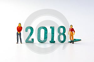 2018 New year concept man and woman miniature figures standing o