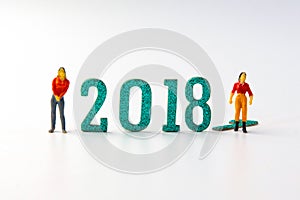 2018 New year concept man and woman miniature figures standing o