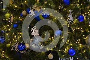 New Year decorations balls on a christmas tree and a glowing garland close up