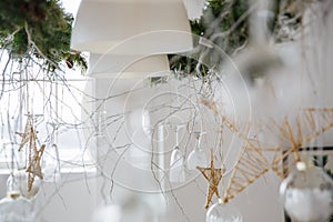 New year decorations in the form of hanging wine glasses and stars made by hand and the branch of the Christmas tree