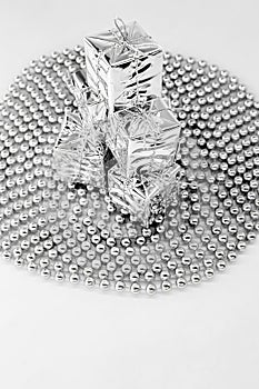 New year decorations - silver small gifts, square reflection toys on top of each other on spiral beads, chain of balls