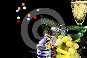 New Year Eve party favors next to glass of Champagne and grapes