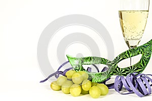 New Year Eve party favors next to glass of Champagne and grapes