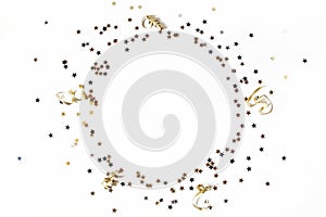 New Year festive composition. Circle made of black, silver and gold confetti stars and ribbons. Party decoration