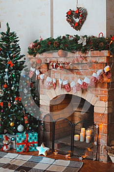 New year festive interior. Christmas tree decorated by the fireplace