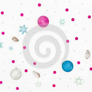 New Year frame composition. Christmas balls and pink confetti on white background. Flat lay, top view