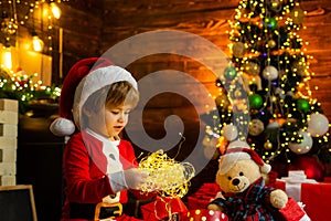 New year garland lights. Christmas time. Happy little child play with xmas decorations. Lovely baby enjoy christmas