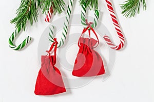 New Year gift. Christmas gift. Red surprise bag. Candy canes and branches of Christmas tree. Flat lay. Copy space