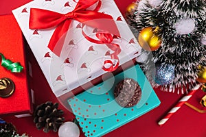 New year gifts and decorations close up, red ribbons, pine cones and bell, christmas