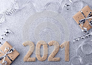 New year gifts, ribbon and tinsel on a silver background with the inscription 2021