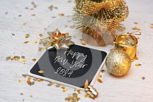New Year holiday background. Lettering on a wooden chalk board with a Christmas tree and ribbons and decoration